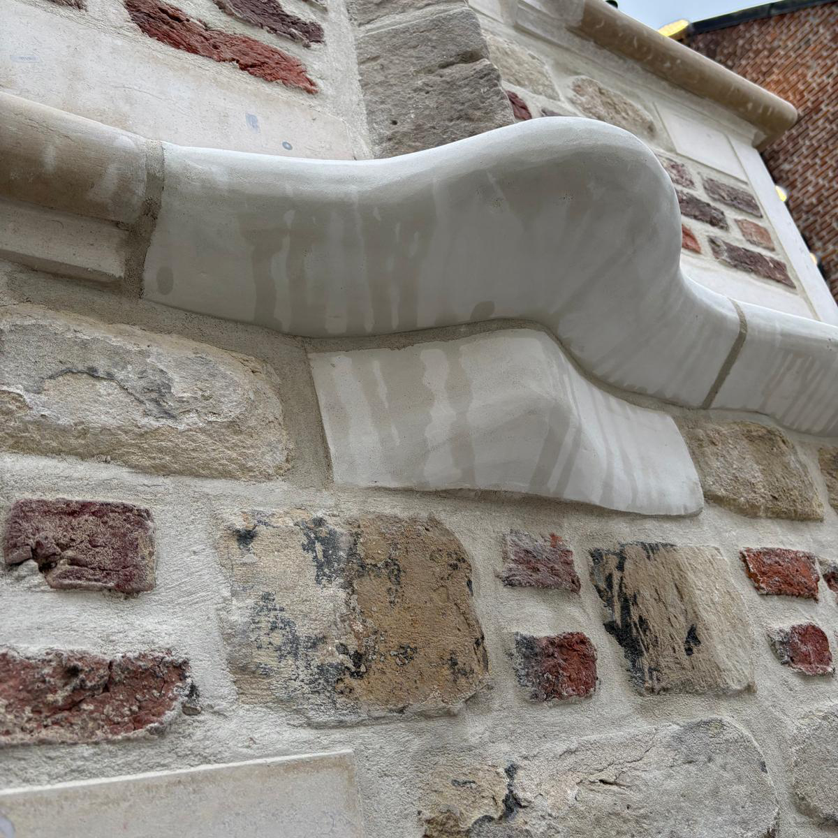 Detail van gerestaureerde natuursteen aan het historische pand Roose in Antwerpen
