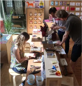 Two customers inside the Pop Press shop participating in a letterpress workshop