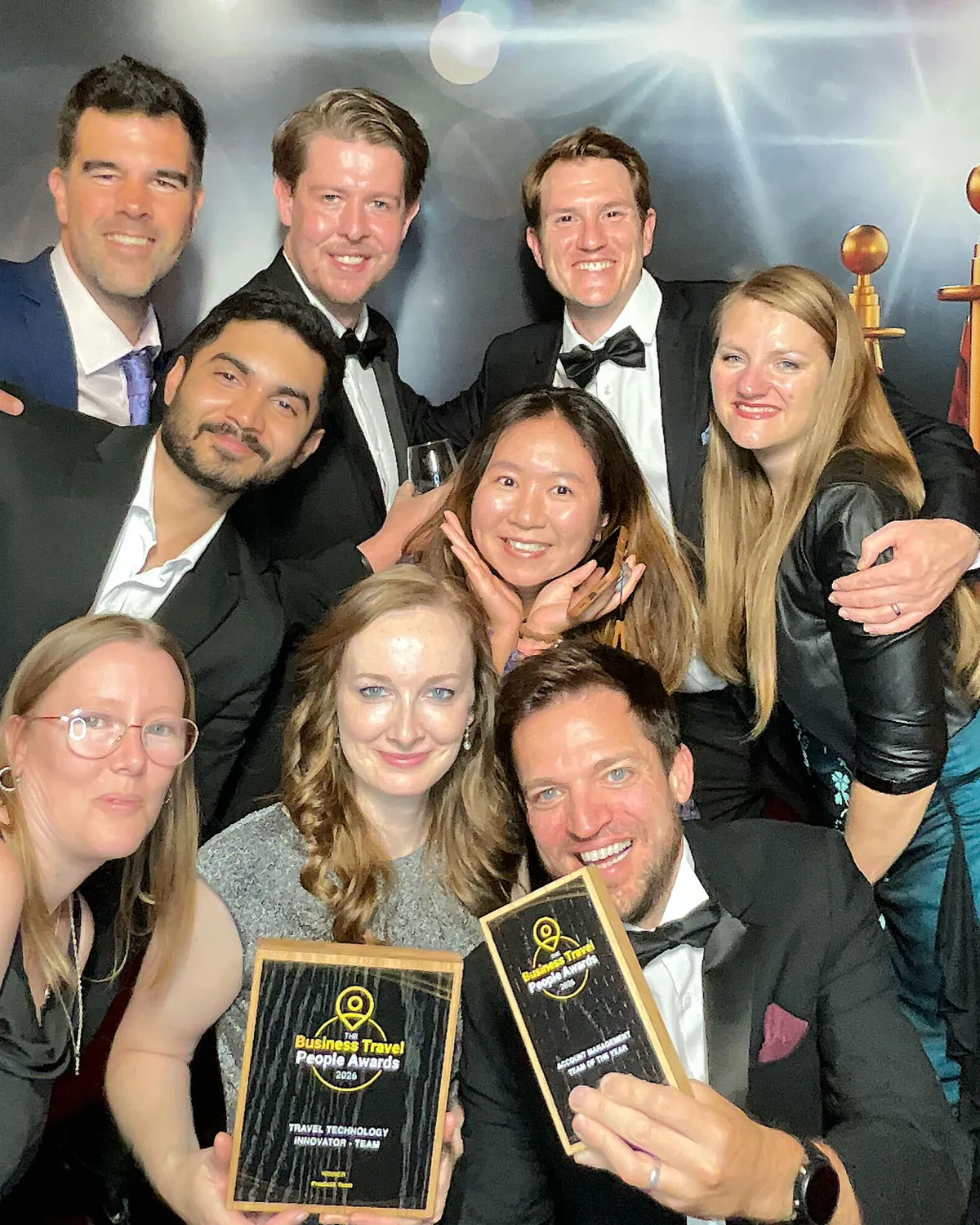 Nine of the team crowd into the photo booth, the winner's plaque held up at the front and the highly commended one beside it