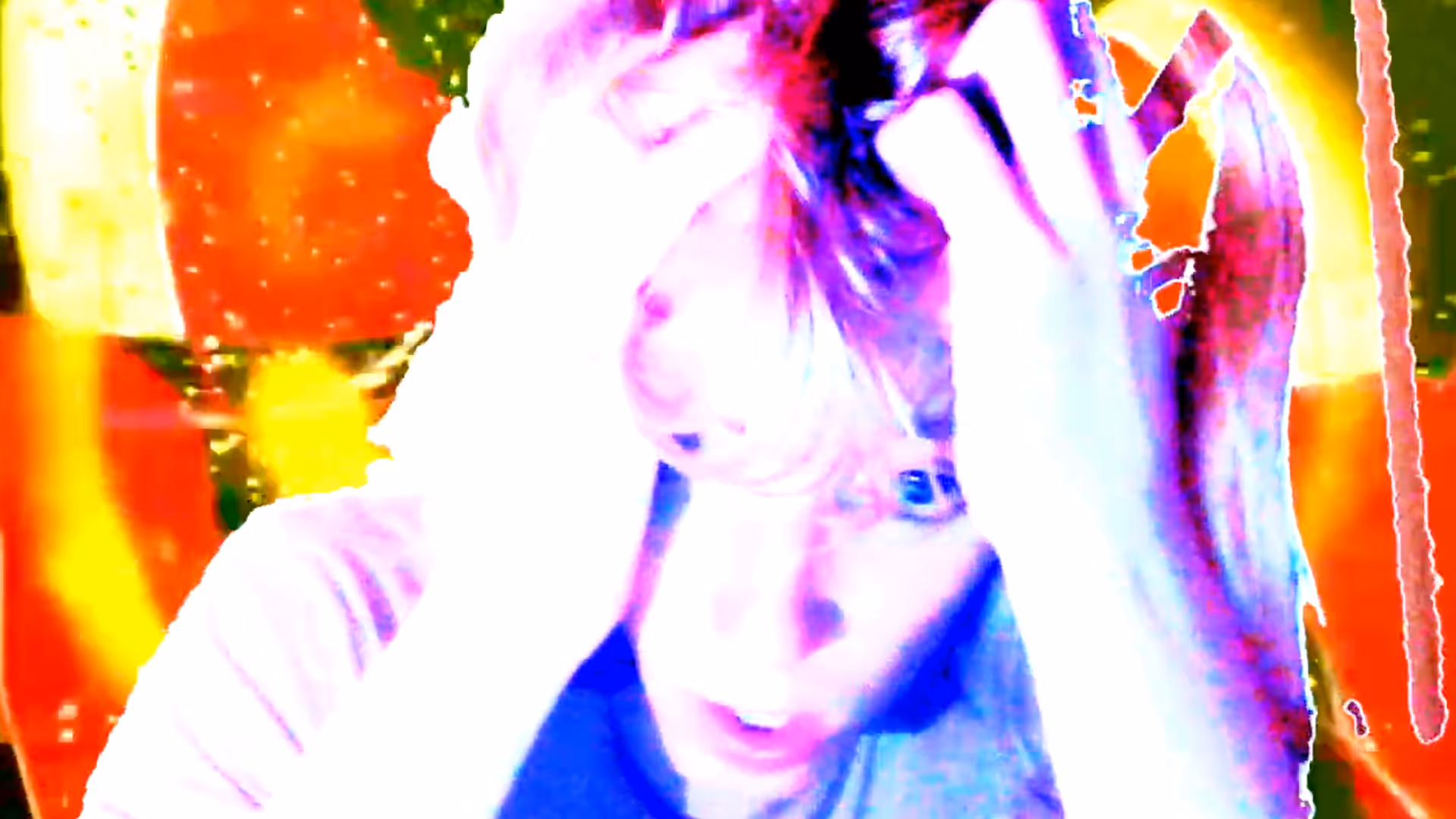 A hyper-saturated close-up of a young woman with light blonde hair and bangs clutching their head with both hands. Her blue eyes look upward through washed-out lighting and swirling rainbow glitch effects.