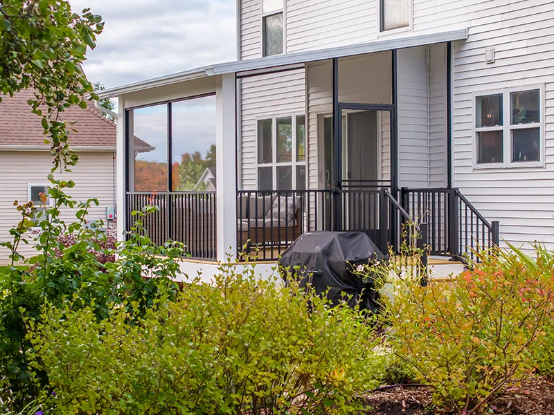 A West Michigan Joyce Studio patio cover with Westbury Screen Rail and Trex Signature Rail