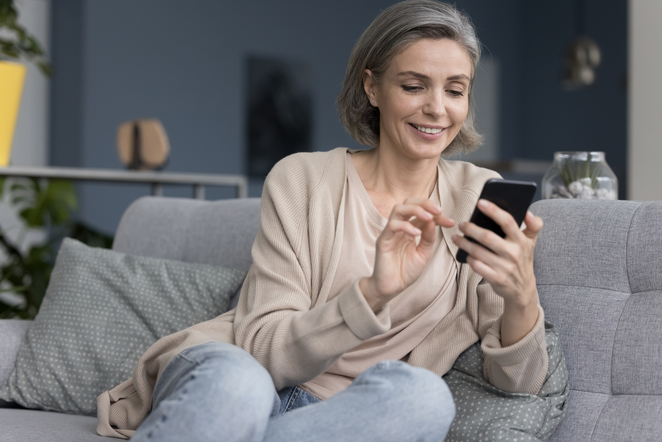 Woman sitting on couch using her smart phone