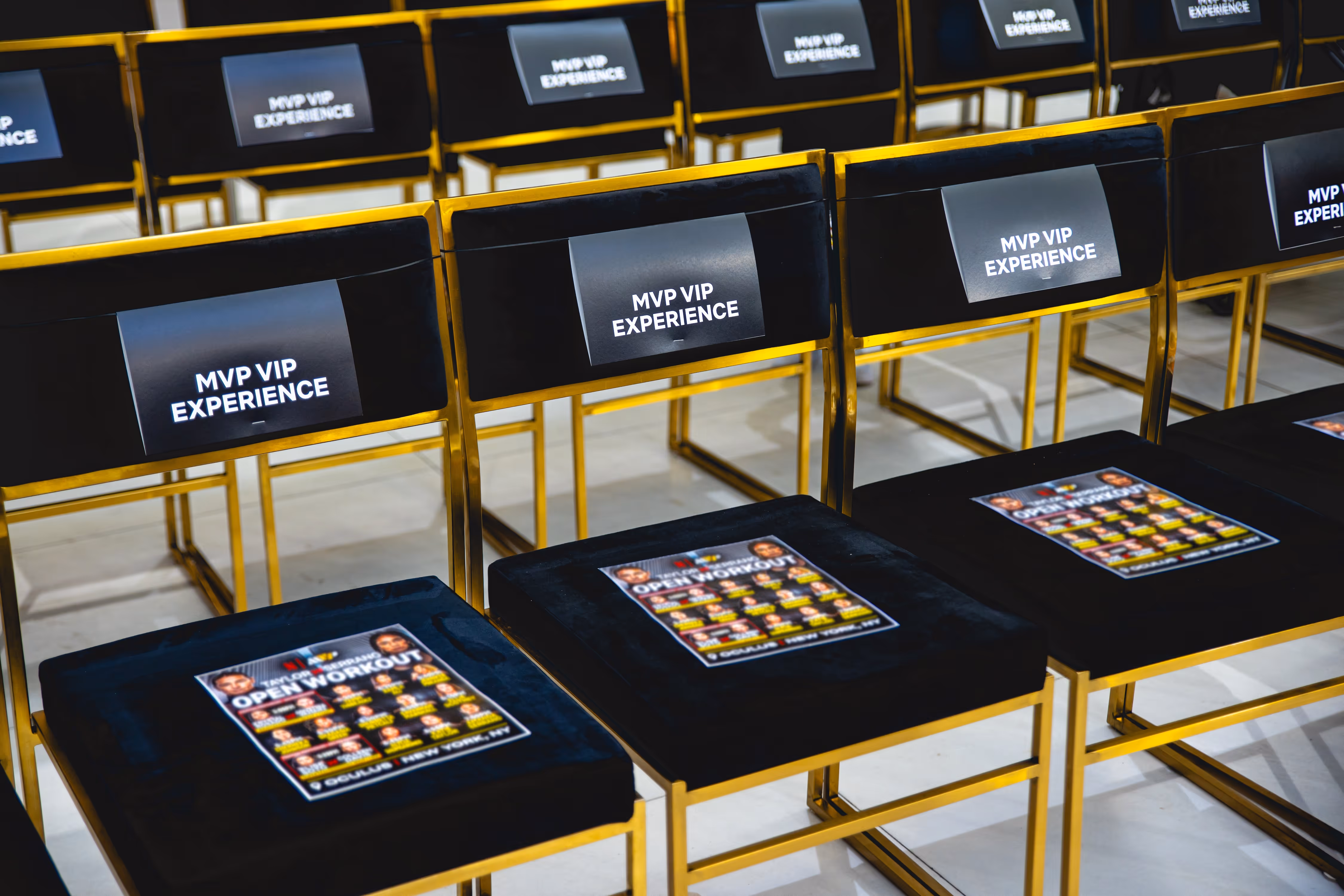 Rows of black and gold chairs labeled MVP VIP EXPERIENCE with promotional flyers on the seats.