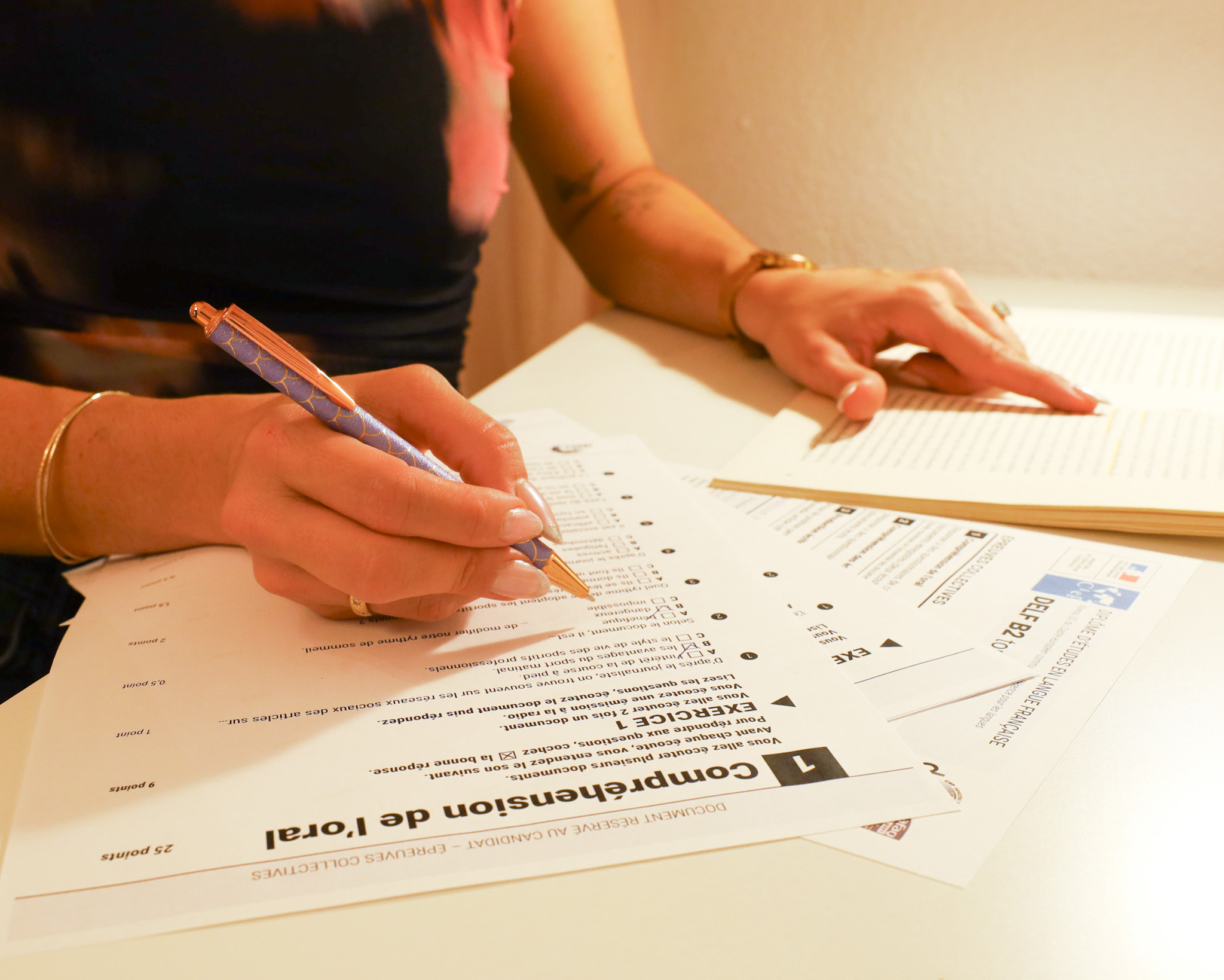 An cropped image of someone sitting at a desk taking notes.