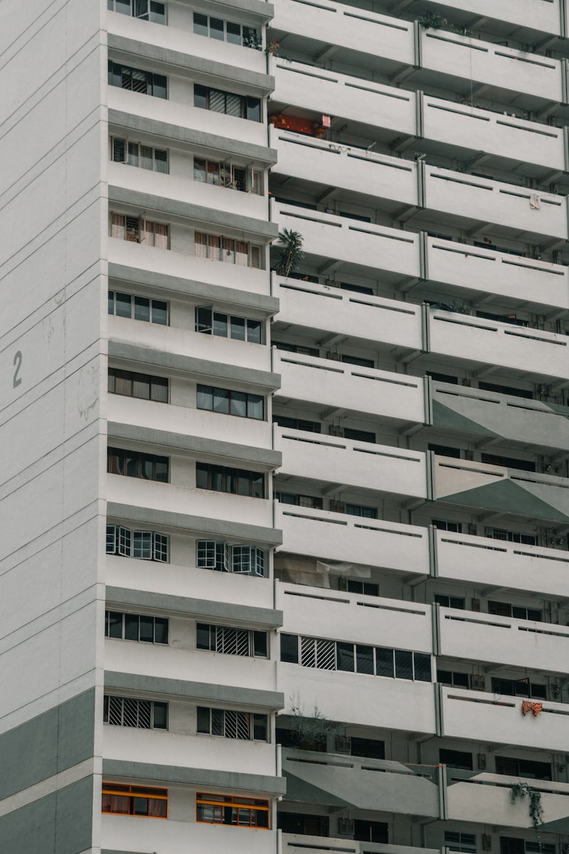 A tall white residential condominium with balconies, representing modern property developments in Malaysia and Singapore