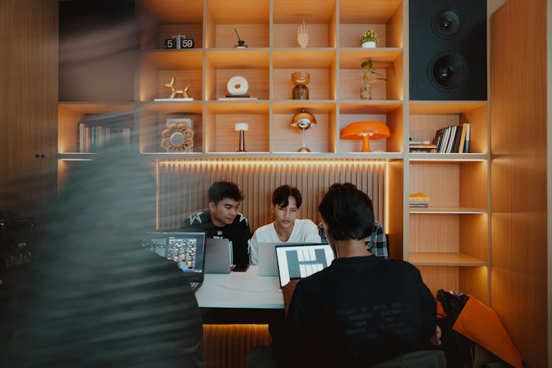 Creative team collaborating on laptops in a studio, representing a full service marketing agency handling online and offline campaigns