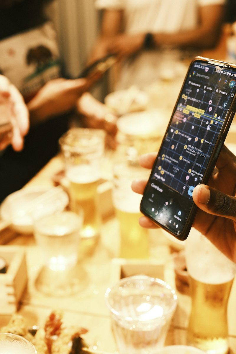 Smartphone with a map app held over drinks at a cafe, illustrating conversational local search