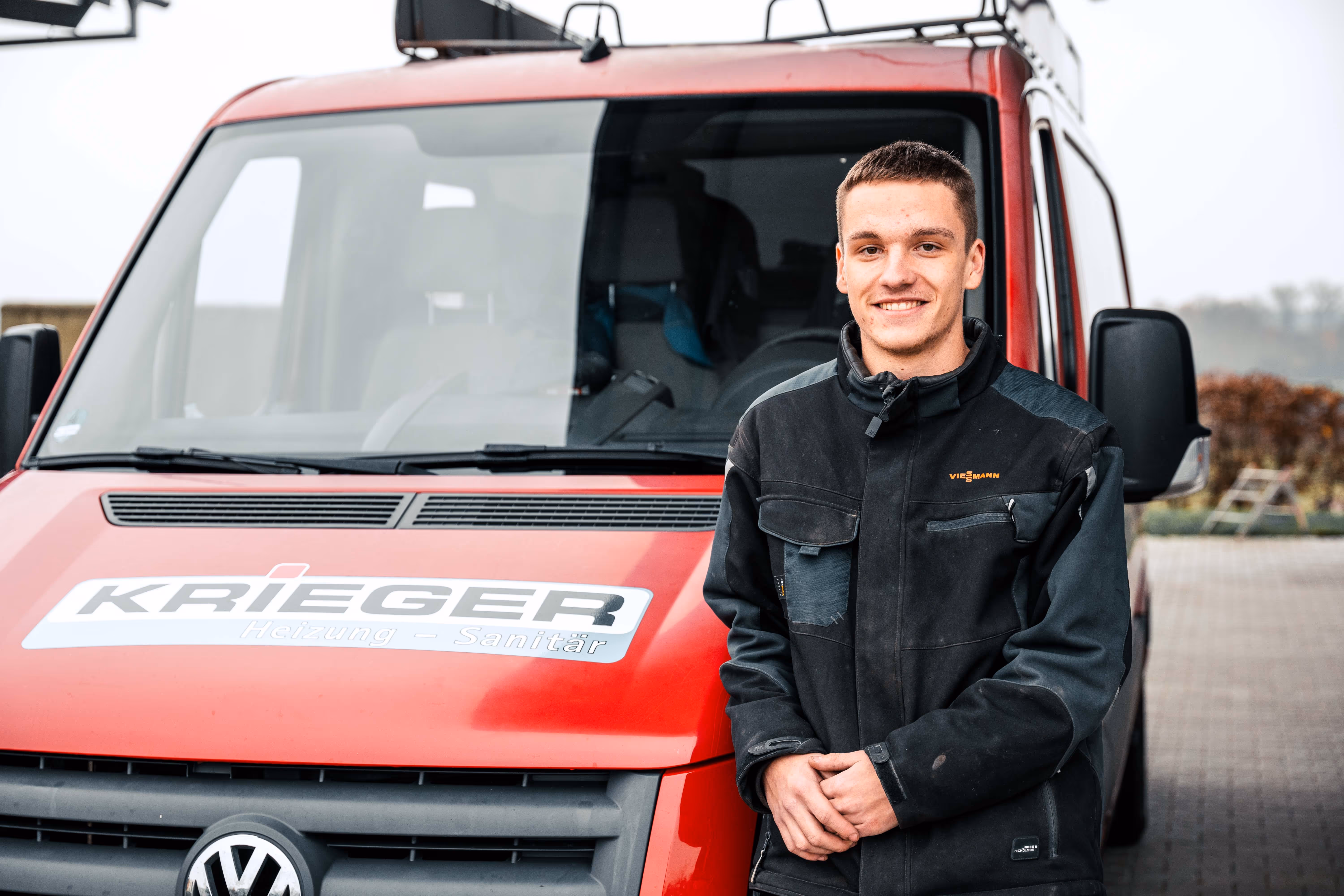 Krieger Azubi vor Firmenwagen auf dem Weg zu Wärme360 Auftrag