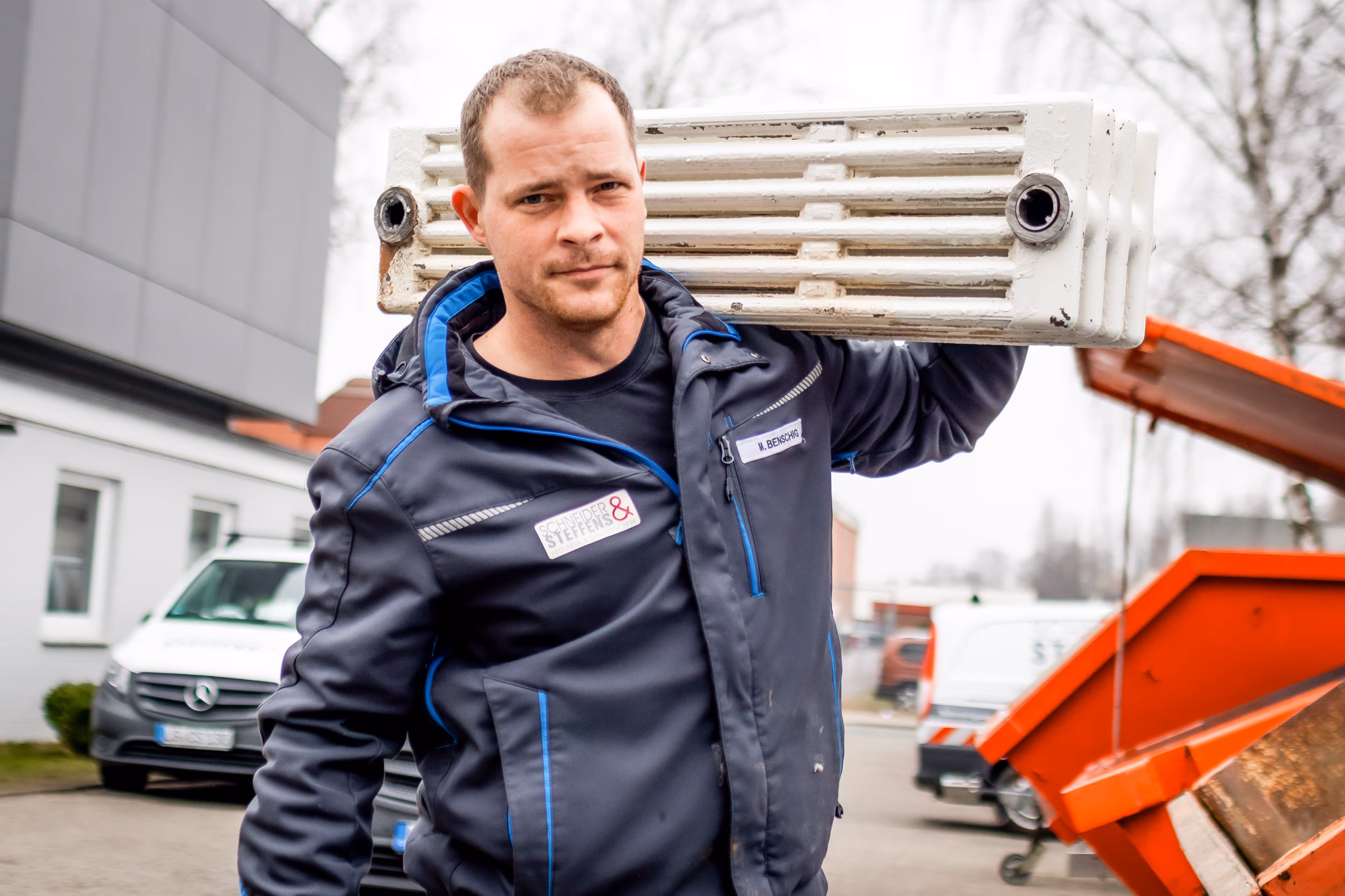 Ein Schneider&Steffens Mitarbeiter mit geschultertem Heizkörper