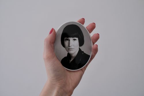 A hand holding a monotone tombstone portrait of the artist Zuzanna Rajewska