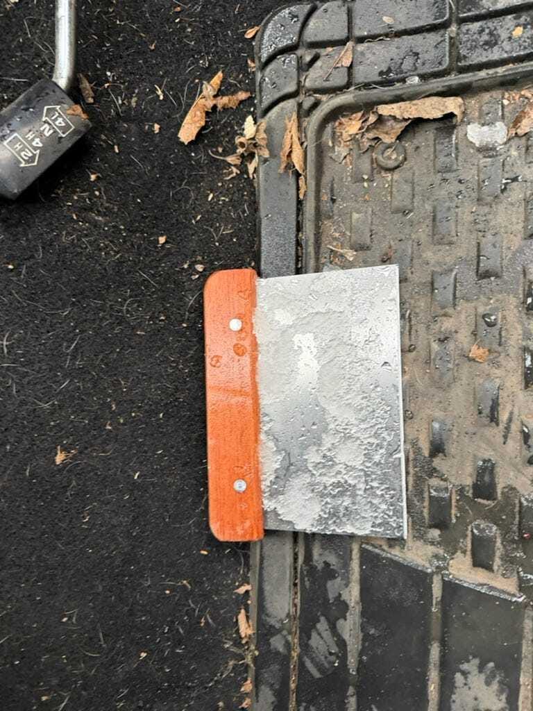 Scraping the windshield with a bench scraper