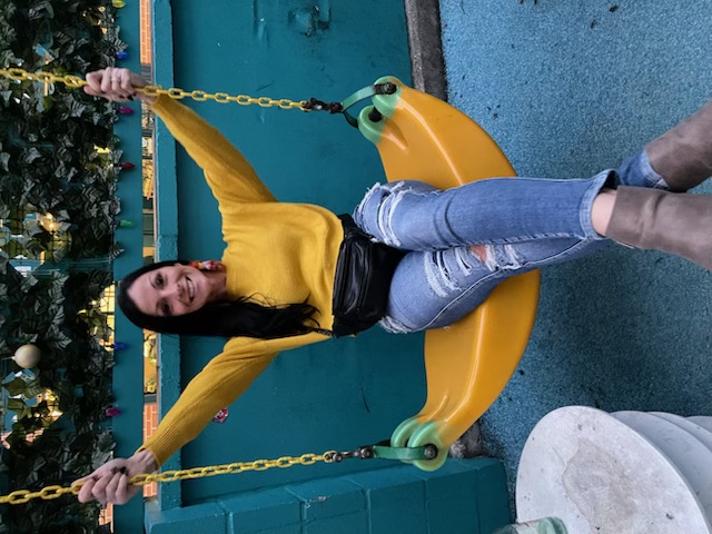 Cole Smyer, Billing Manager of Austin Rent Fence, smiling with arms crossed, wearing a navy shirt with the company logo, standing in front of a window with greenery in the background.