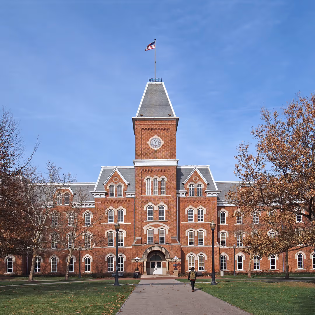Traditional brick university building with a clock tower and campus grounds, leading to Reliant’s education coffee service page.