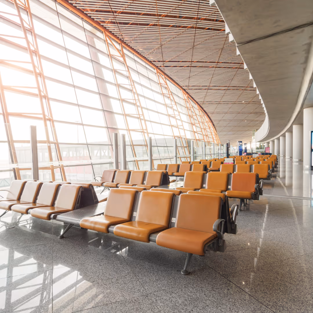 Modern airport terminal waiting area with rows of seating and large windows, leading to Reliant’s lounge coffee service page.