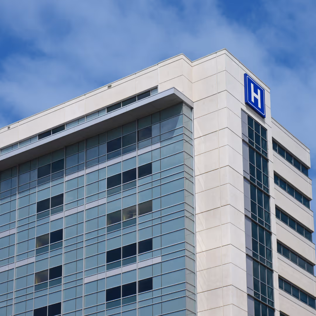 Modern healthcare building exterior with a visible blue hospital sign, leading to Reliant’s medical coffee service page.