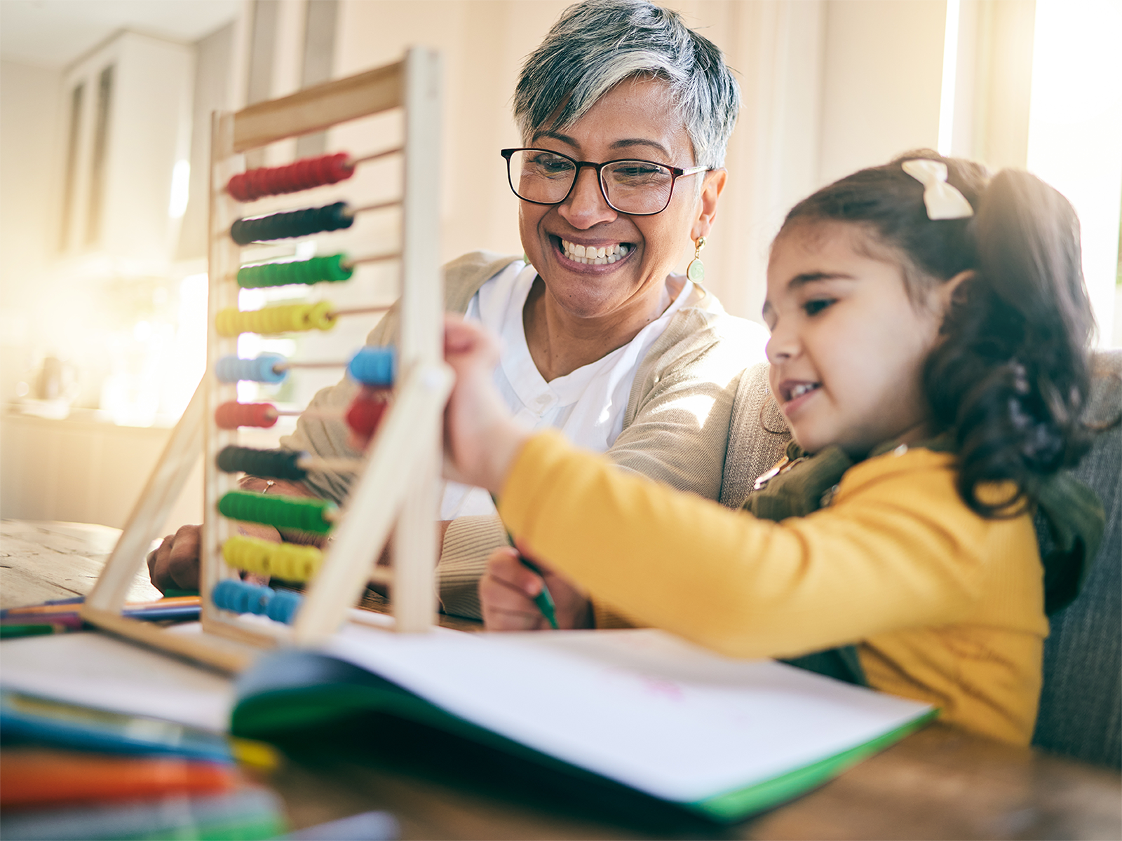 An older woman presumably a grandmother helps a young child with math