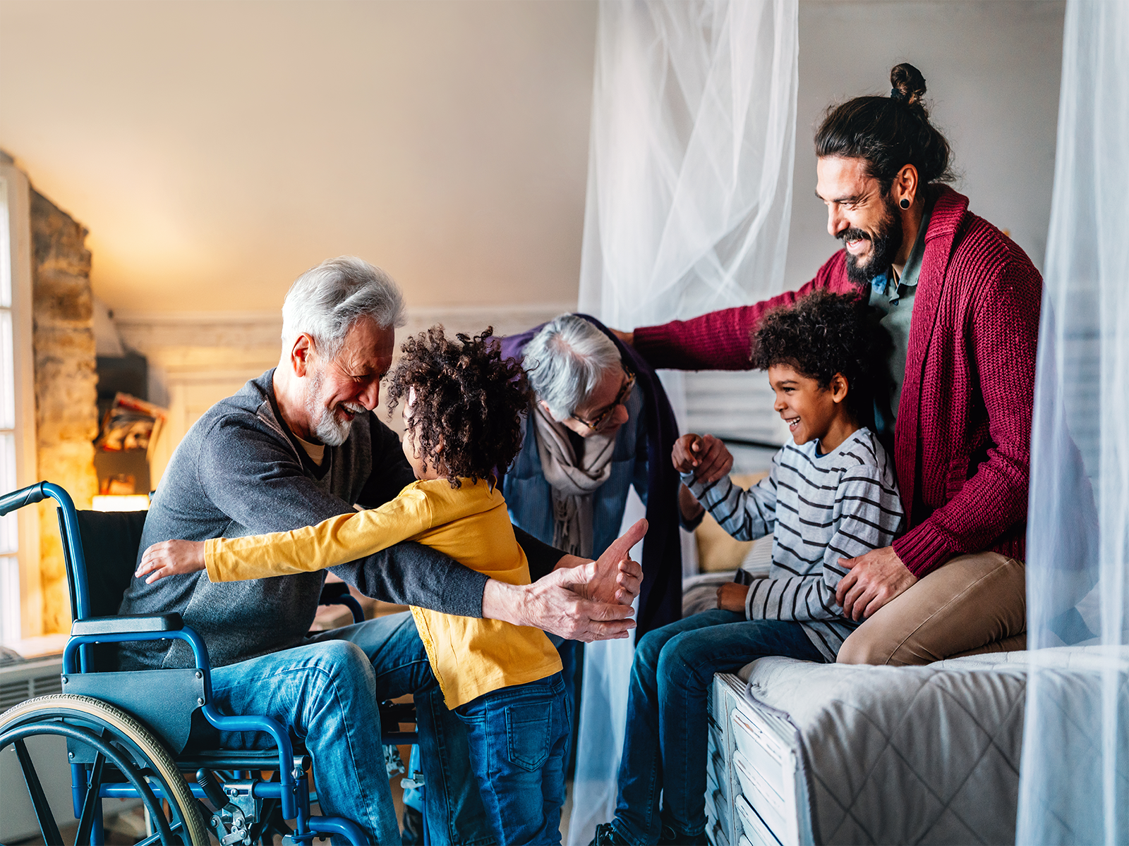 A grandfather reaches out to hug his grandchild surrounded by family