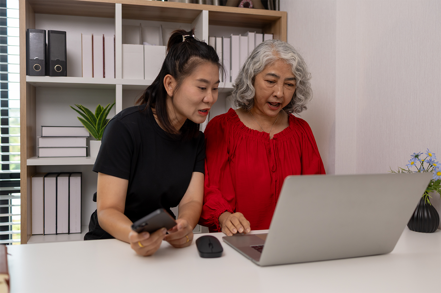 A daughter and her aging mom are on a laptop at home.