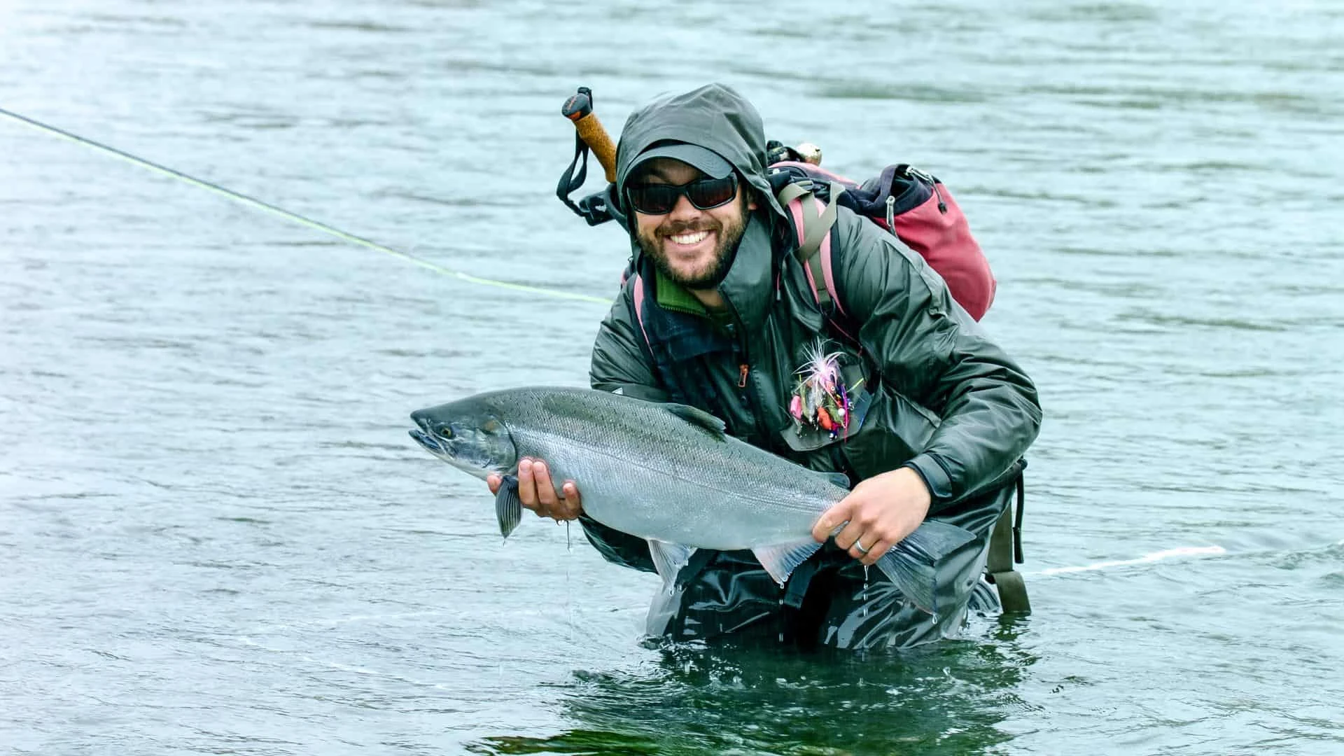 Classic Casting Fishing guide Tad holding a silver salmon in Sitka Sound.