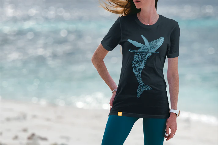 Woman wearing a Sitka Wonders whale art shirt on a beach in Alaska.