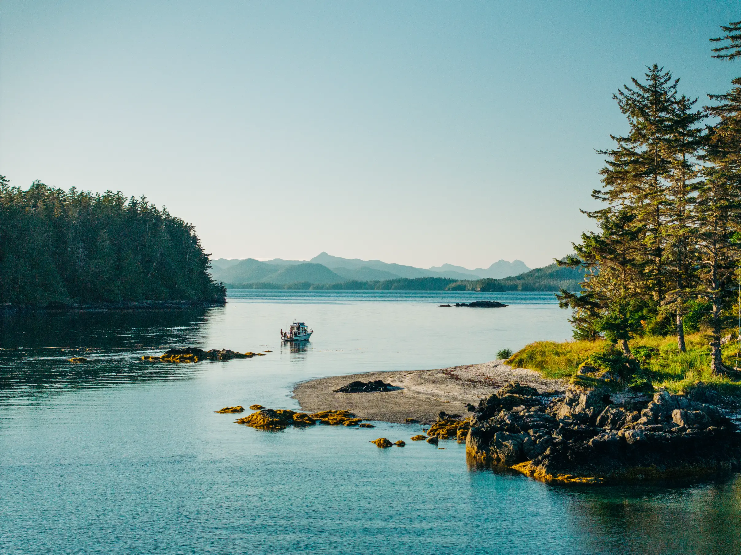 Small wildlife watching Sitka Wonders boat exploring the islands around Sitka Alaska on a blue sunny day forest. 
