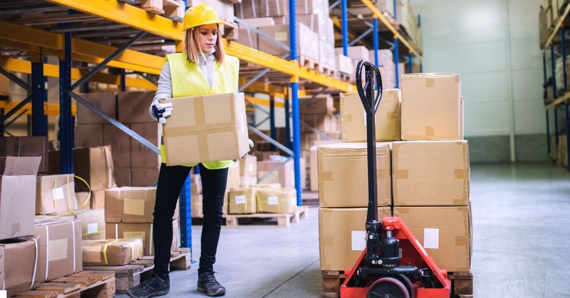 a warehouse worker picking a box with a trolley