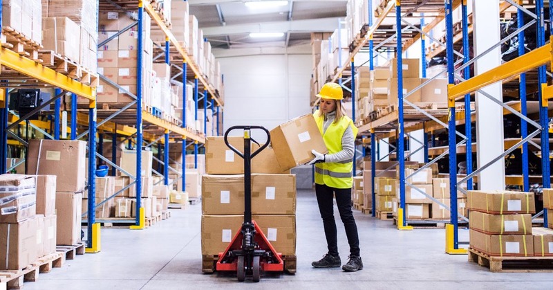 a warehouse worker picking up a bunch of boxes