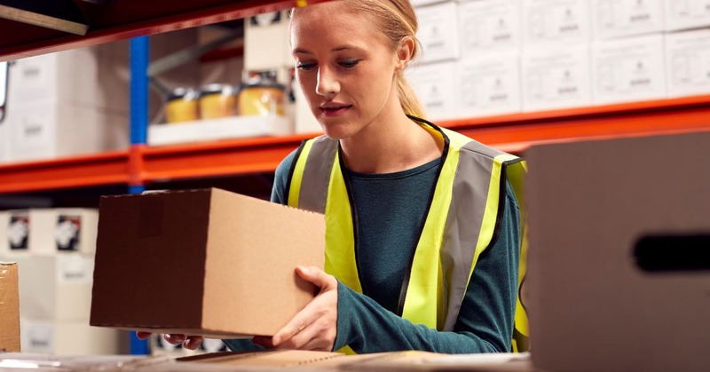 a warehouse employee picking up a case box