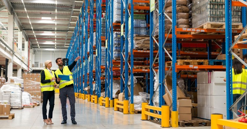 two people checking packages on a warehouse