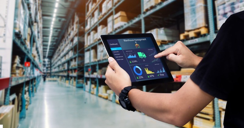 a warehouse employee holding a tablet with a graph report