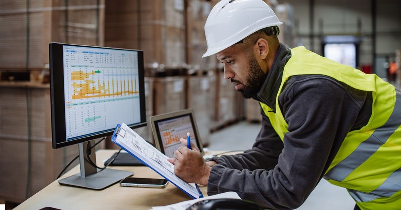 a warehouse worker looking at the report