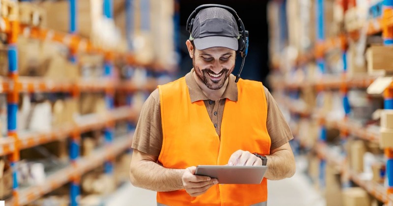 a warehouse worker looking on his tablet