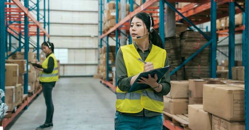 a warehouse worker's with headsets while checking their lists