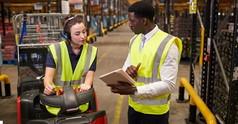 a warehouse worker's discussing while looking on the list