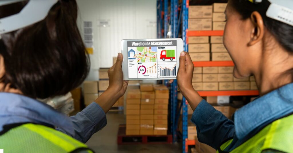 a warehouse worker's looking at a tablet with the displays about warehouse management