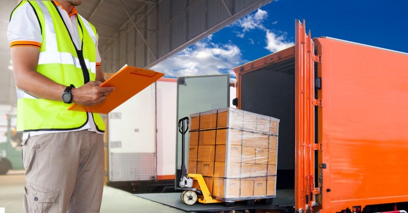 a warehouse employee checking his list of receiving items