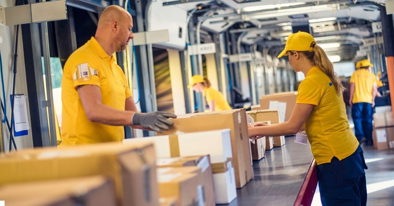 a warehouse worker's picking up a bunch of boxes on a conveyor