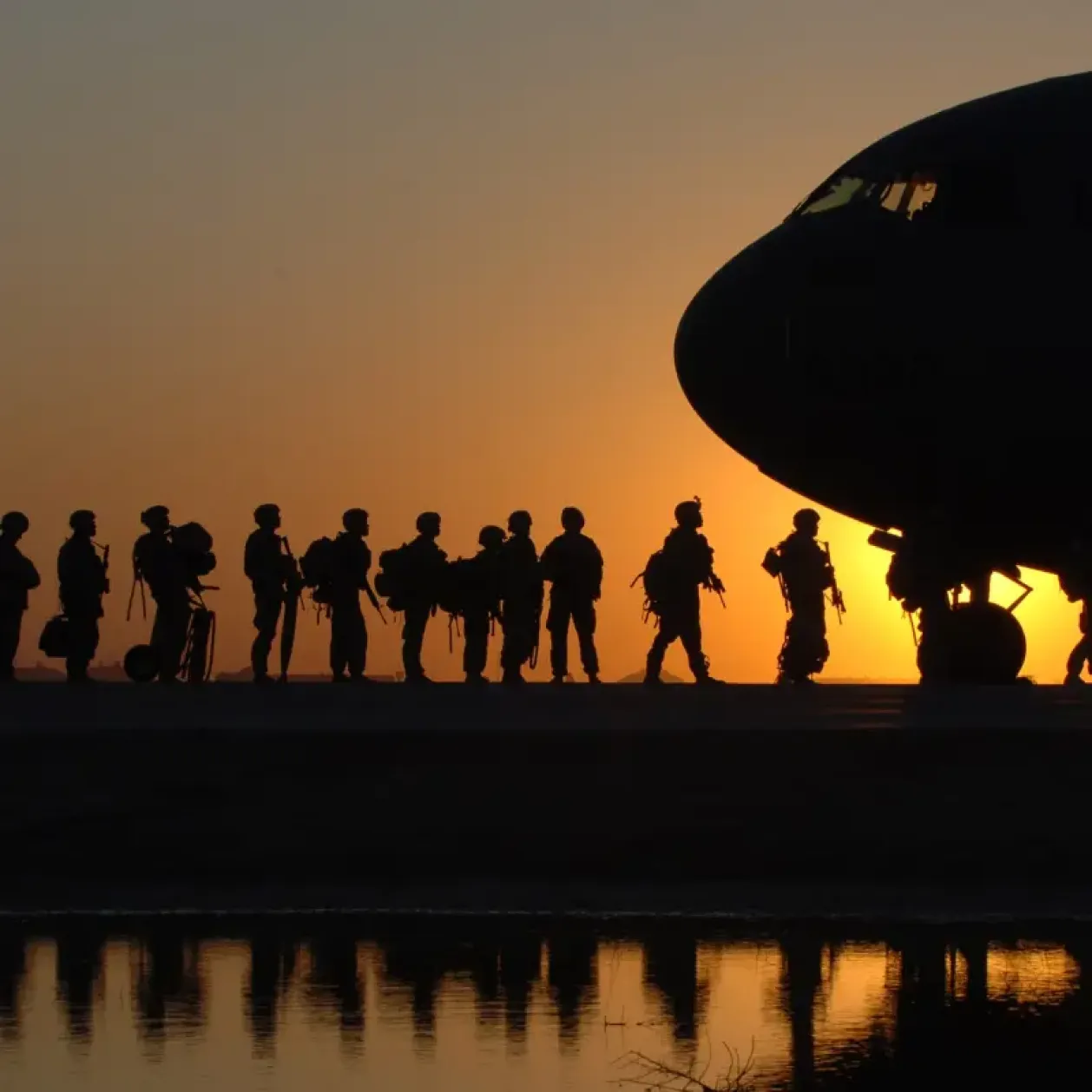 A picture of Canadian Soldiers with Canadian Forces getting ready to take a plane at sunset.