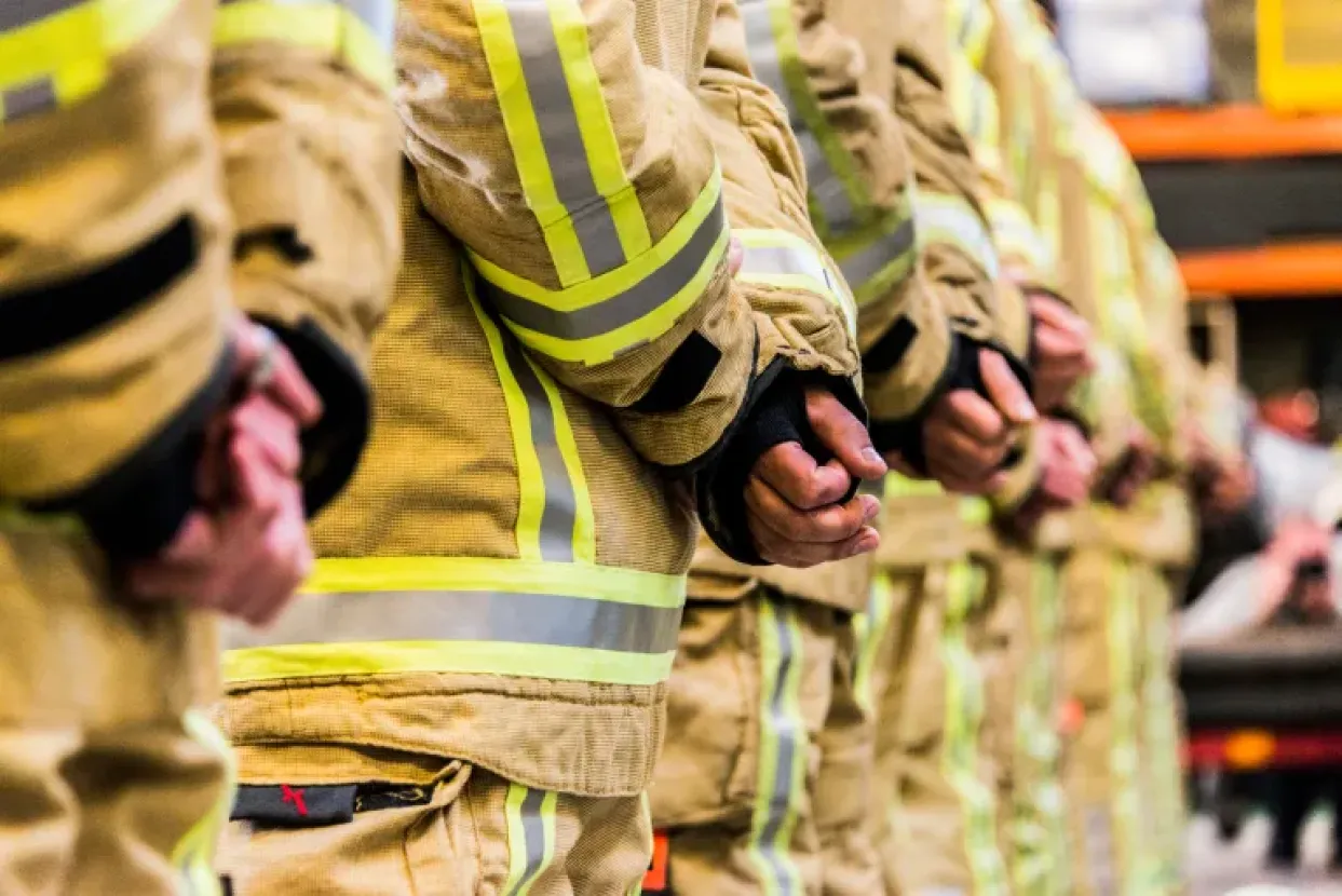 A picture of Firefighters in their uniform with holding their hands behind their back.
