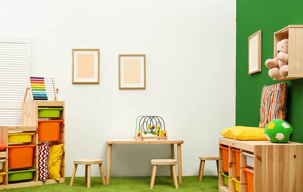 Play area with a children's table, chairs, and open shelves with storage boxes.