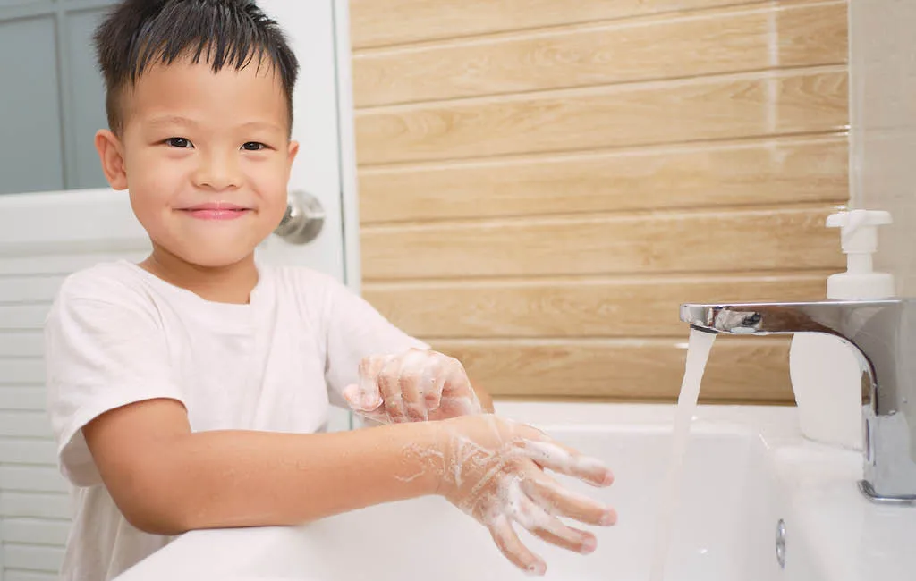 A child is washing their hands with soap.