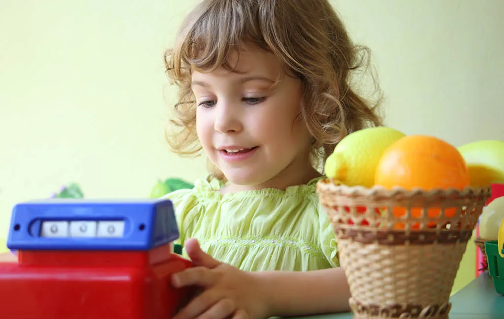 Child playing with a toy cash register.