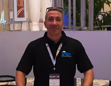 Man wearing a black HHWA polo shirt and lanyard at the ECAP 2018 conference