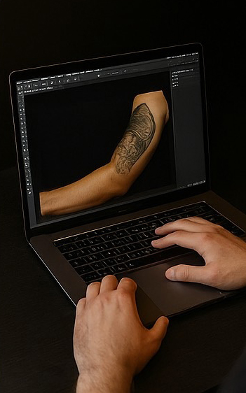 Tattoo-Artist erstellt am Laptop digitale Entwürfe und passt das Motiv an die Anatomie des Arms an.