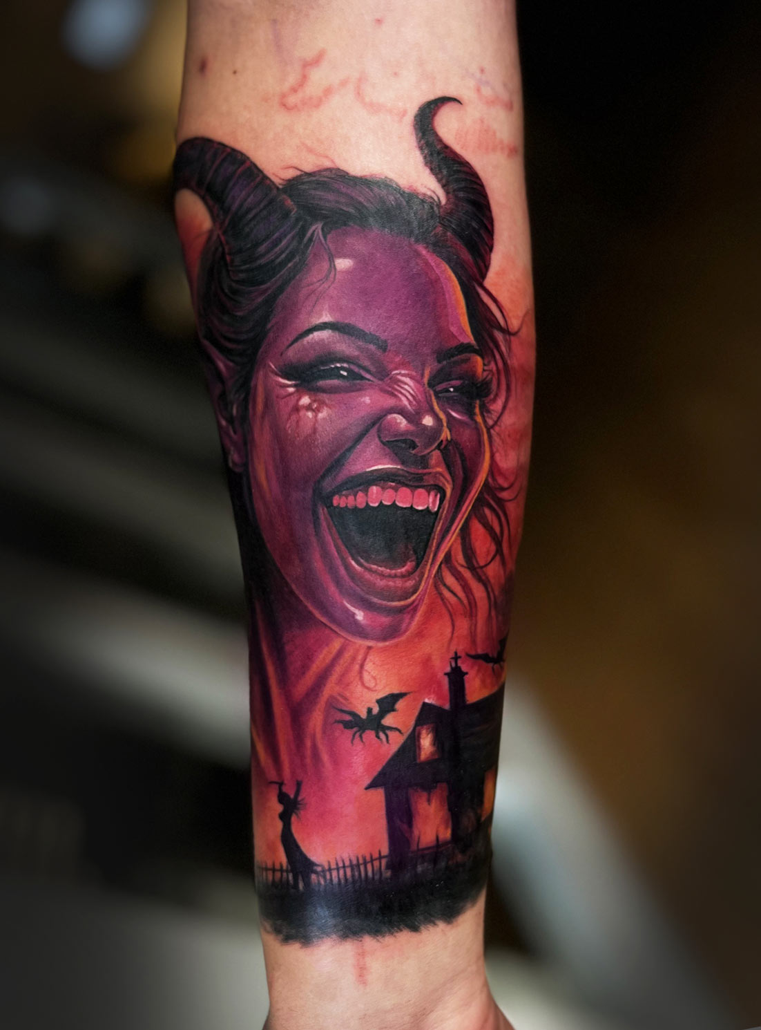 Farbiges Fantasy-Tattoo mit Dämoninnenporträt und Burg am Unterarm.