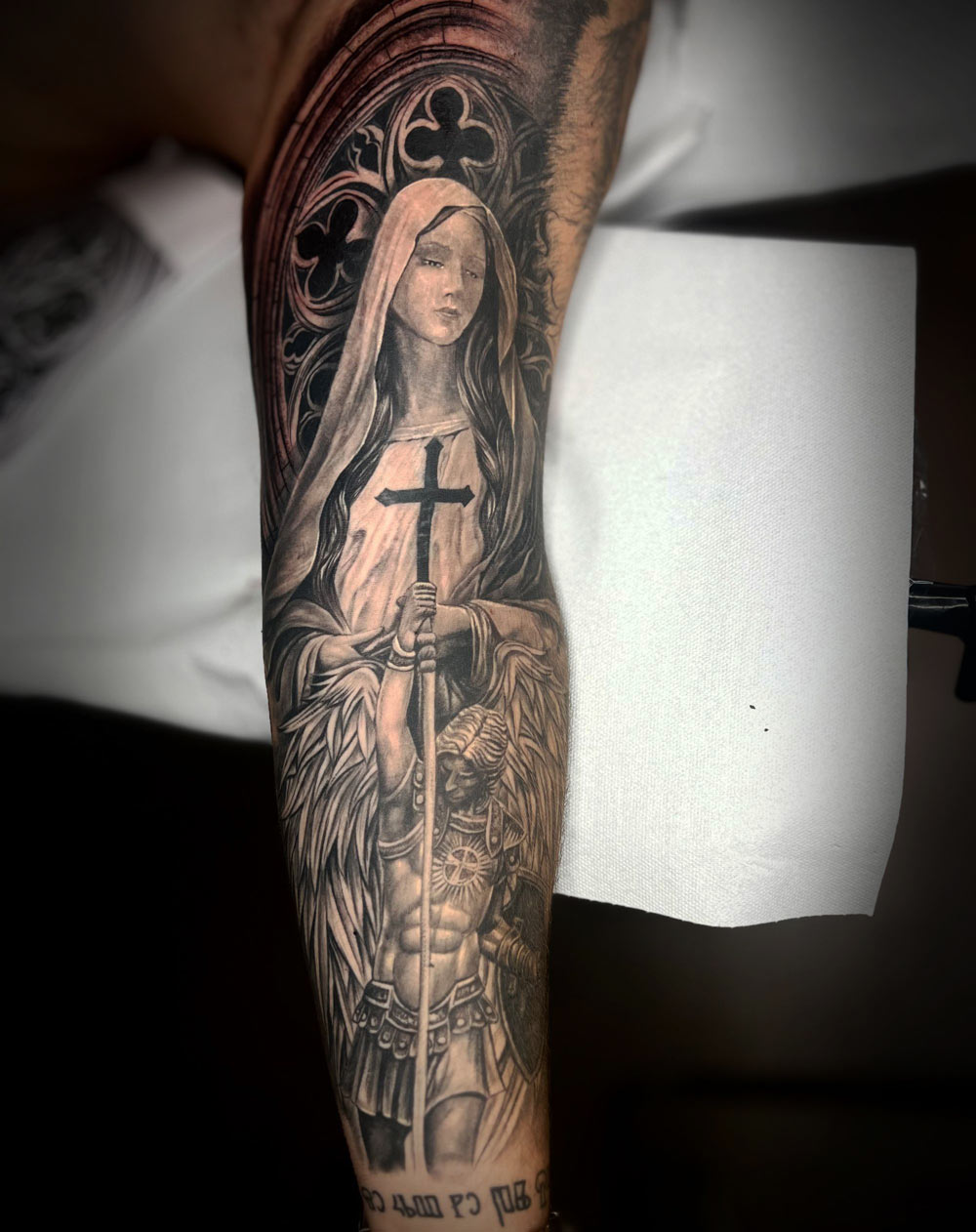 Maria mit ein Angel Michael eines Black & Grey Tattoos auf dem Arm, gestochen im Avantgarde Tattoo Studio München.