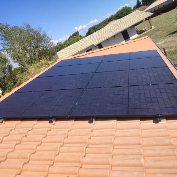 Installation de panneaux solaires photovoltaïques et thermiques sur le toit d'une maison pour production d'électricité et eau chaude écologique.