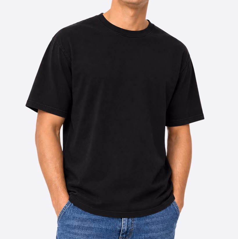 Man wearing a plain black short-sleeved t-shirt with hands in the pockets of blue jeans, against a white background.