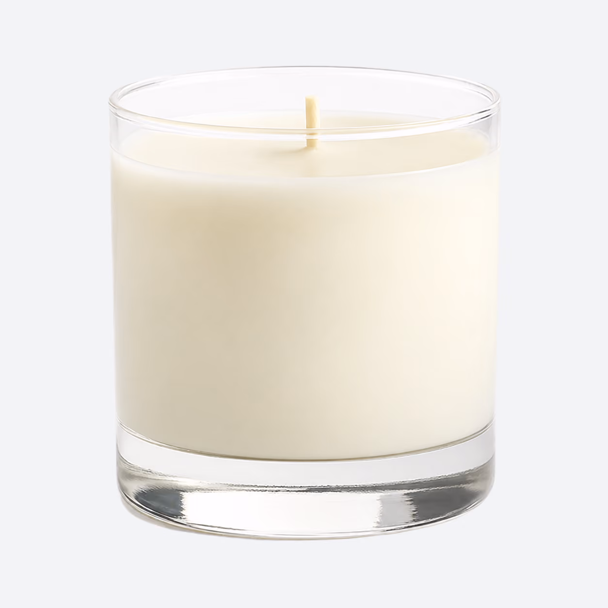 Unlit white candle in a clear glass container on a white background.