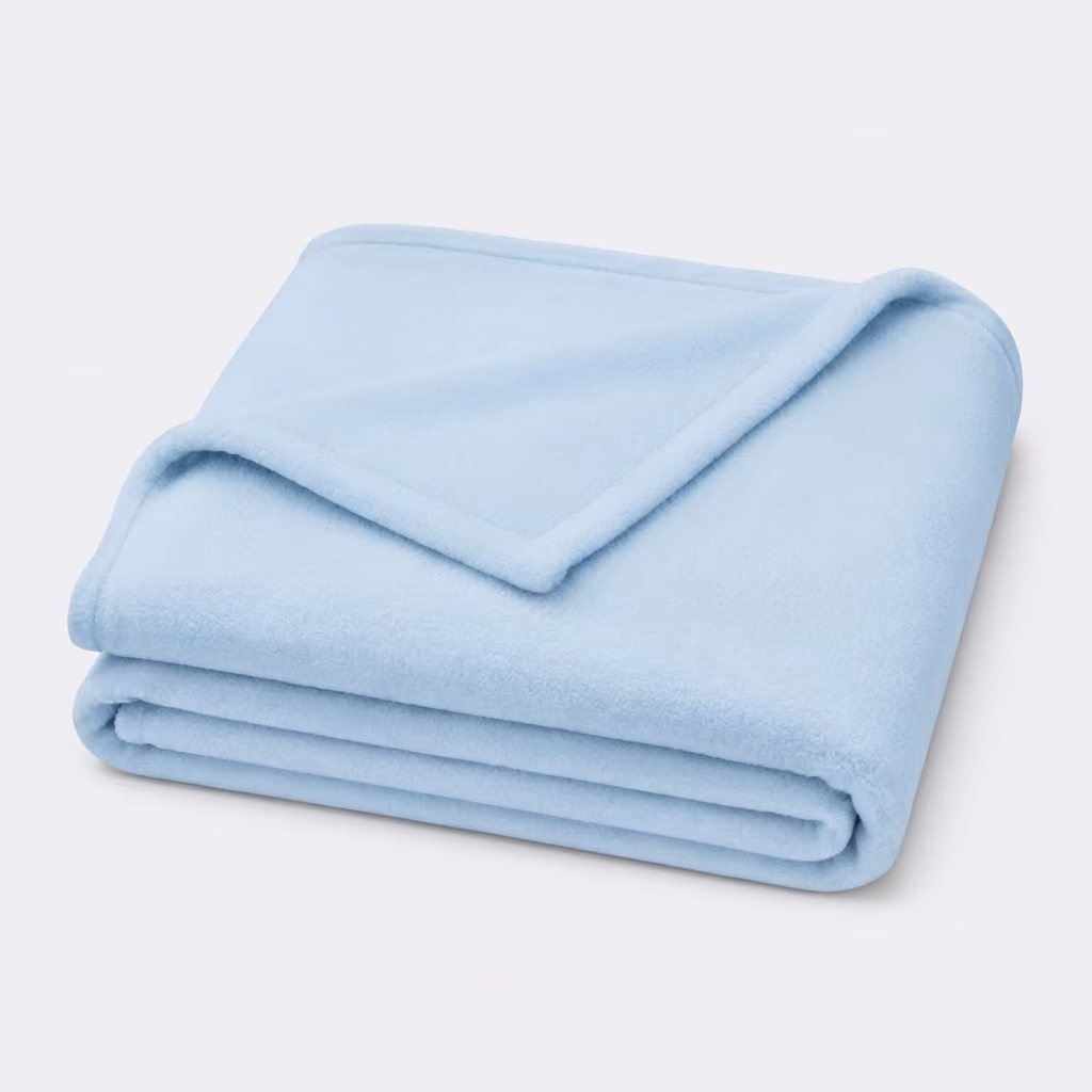 Light blue fleece blanket neatly folded with one corner turned down on a white background.